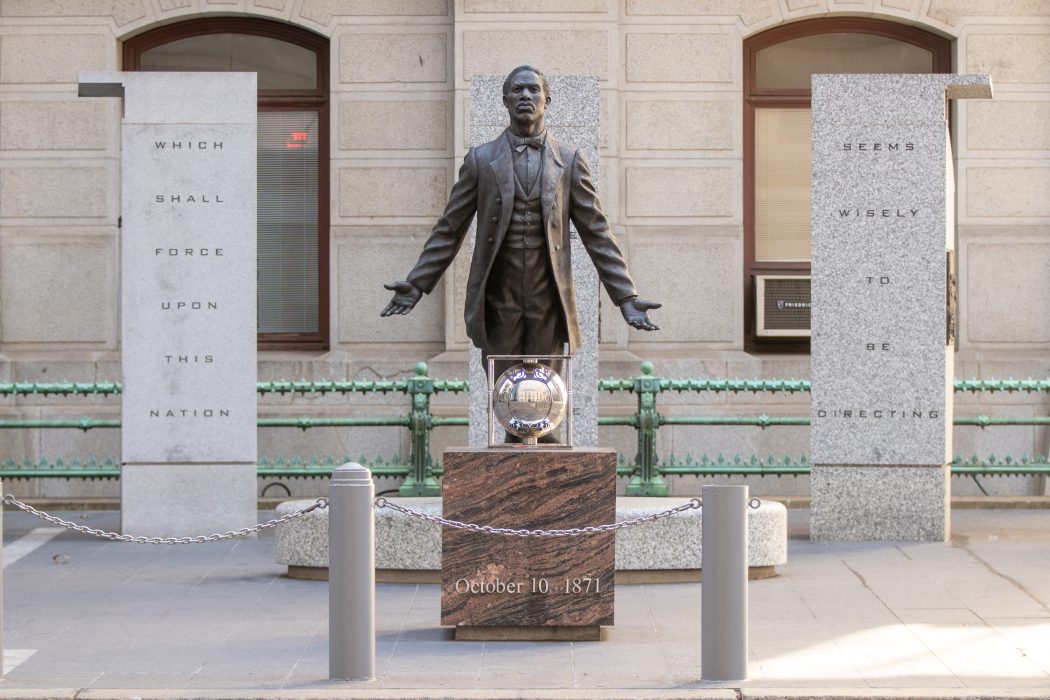A statue of Octavius Catto in the middle of two pillars
