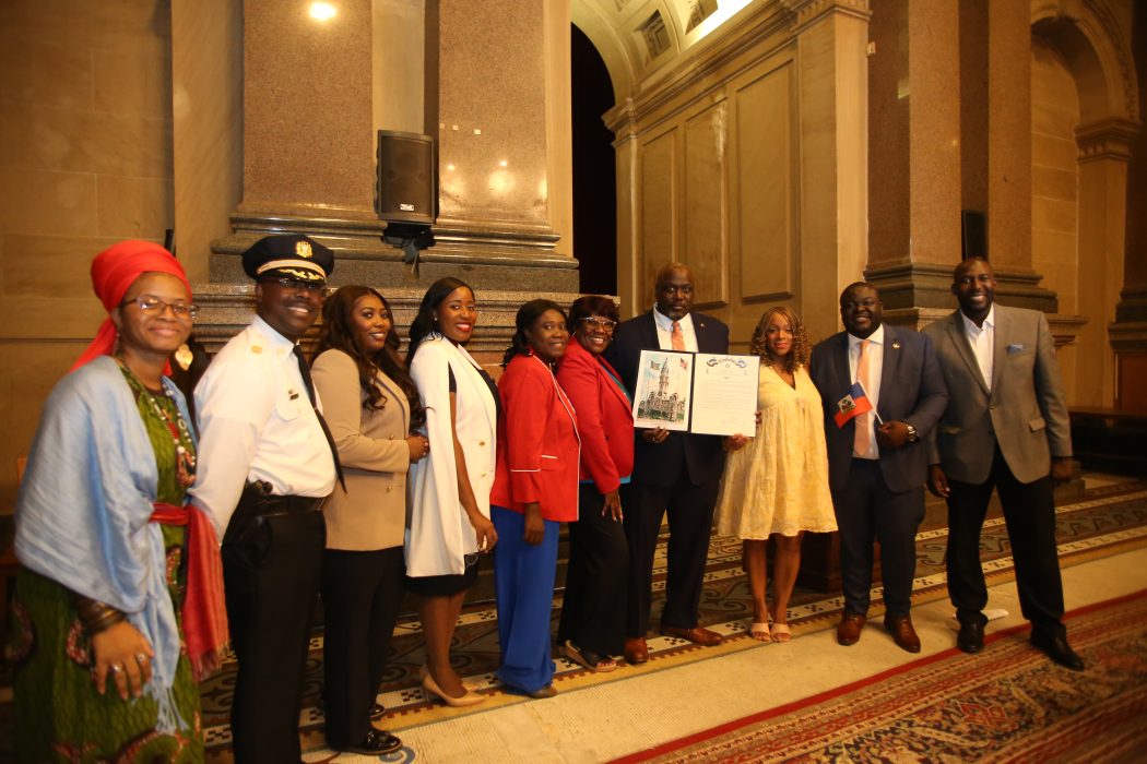 Leaders from Haitian Community Celebrate Haitian Flag Day at City Hall by posing in a picture.