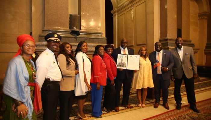 Leaders from Haitian Community Celebrate Haitian Flag Day at City Hall by posing in a picture.