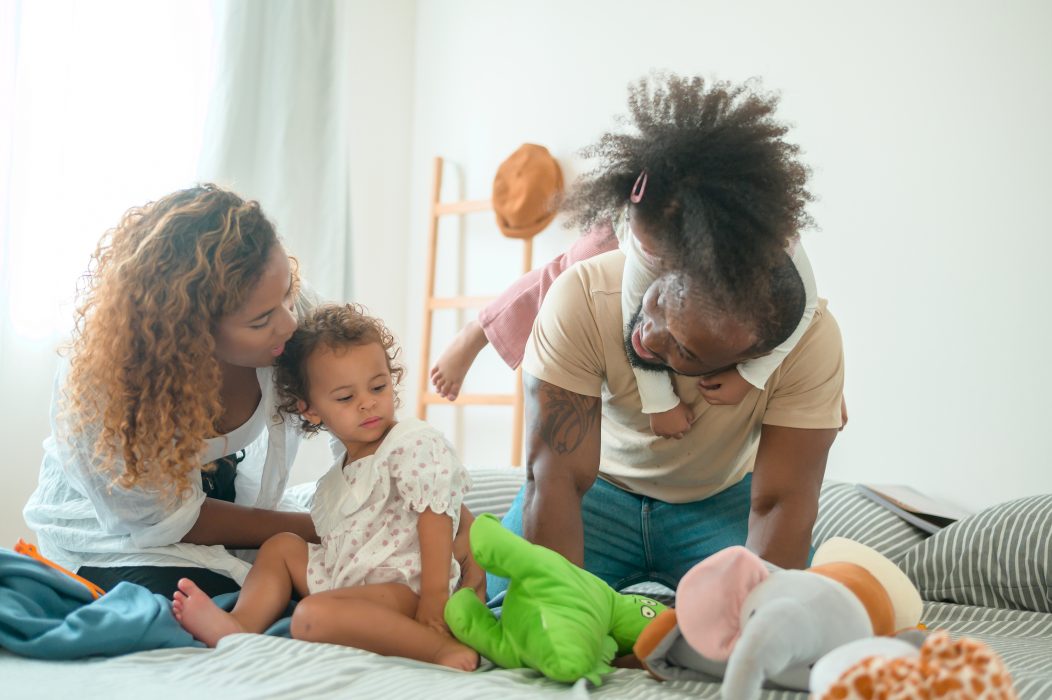 Two parents and their two young children relaxing and enjoying their new home.