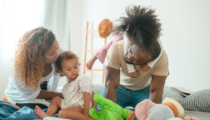 Two parents and their two young children relaxing and enjoying their new home.