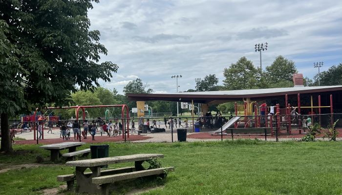 Children playing at a playground and sprayground on a sunny, hot day.