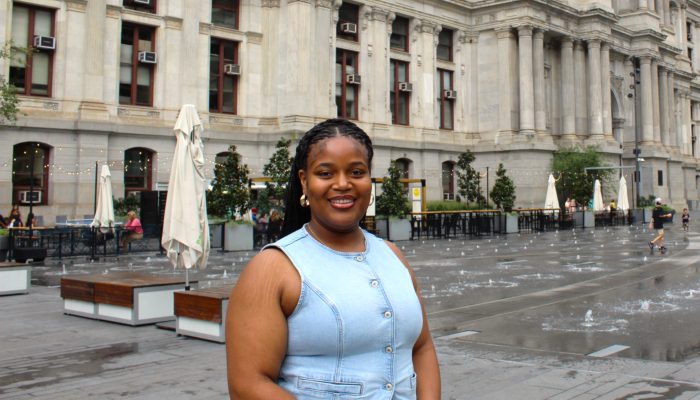Kai Moore, MIP Intern standing in front of City Hall at Dilworth Park