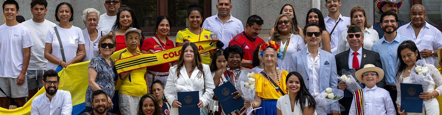 Large crowd poses for group photo at 2025 Colombian Flag Raising Ceremony outside City Hall