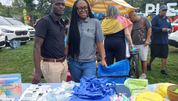 Macfarlen and T. Grimmage tabling an event in a park.