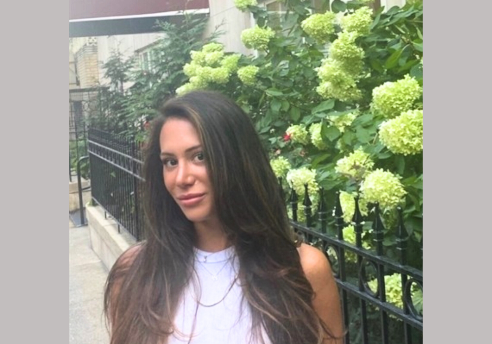 Picture of Allison Teti with a fence and trees behind her.