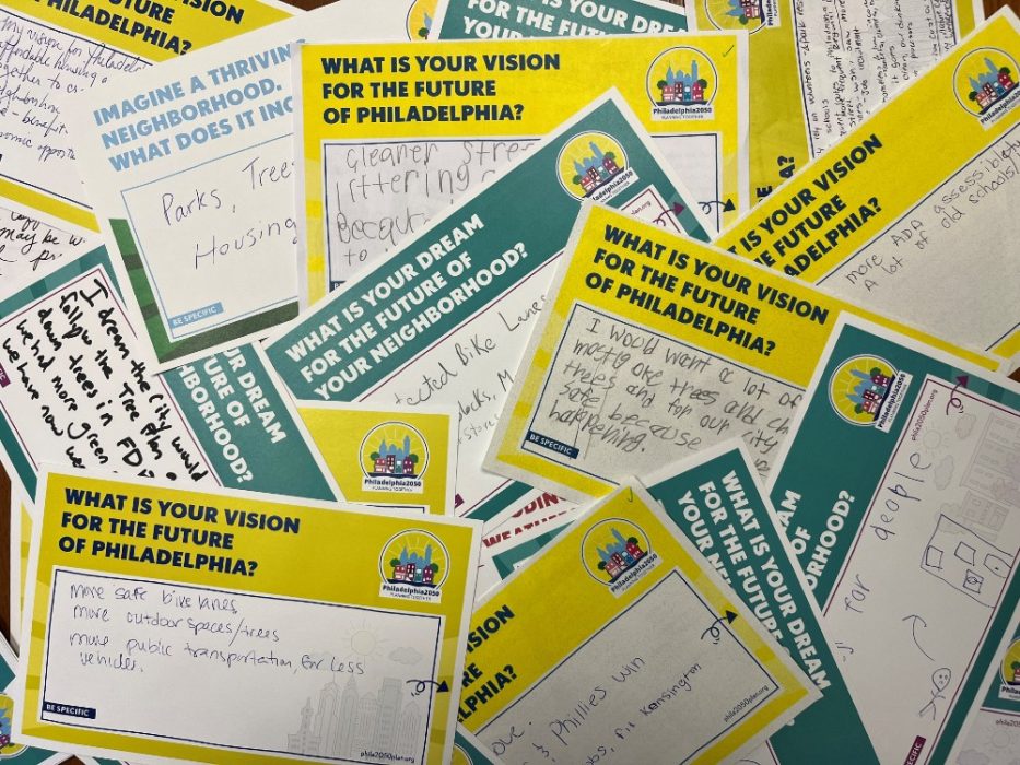 A collection of completed Vision Card Surveys. The cards are about the size of a postcard and ask questions like What is your vision for the future of Philadelphia?" Responses are hand written.