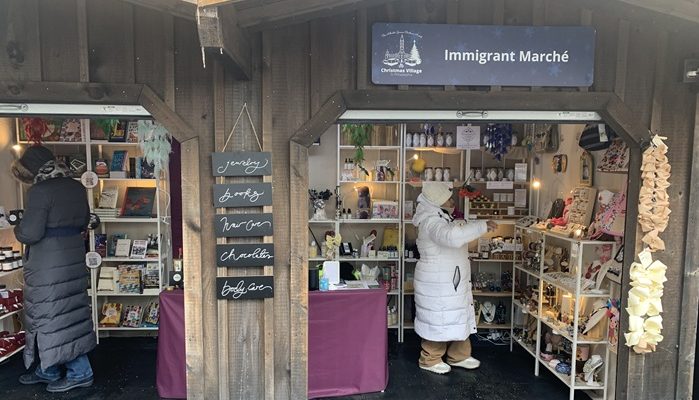 People shopping at The Welcoming Center's booth at Christmas Village