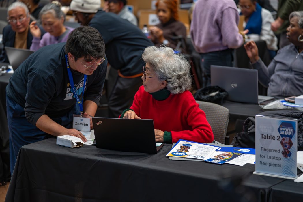 digital navigator assisting resident accessing their new laptop.
