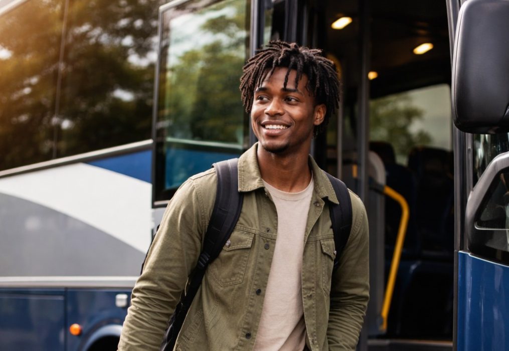 Stock image of a smiling African American man exits an intercity bus.