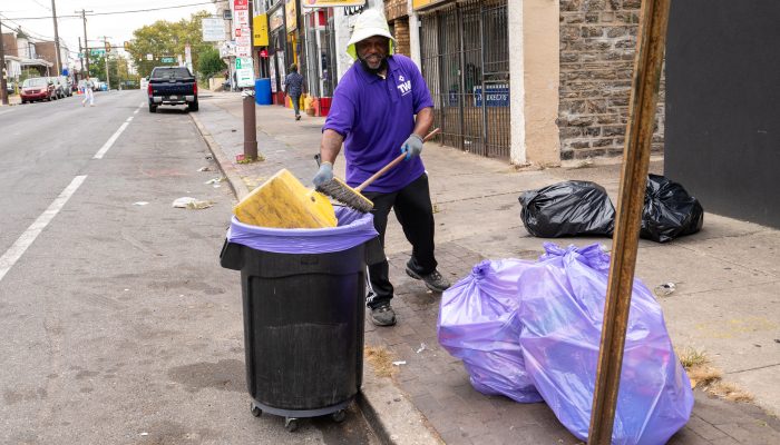 A TCB Cleaning Ambassador cleans the sidewalk along North 5th Street in Philadelphia