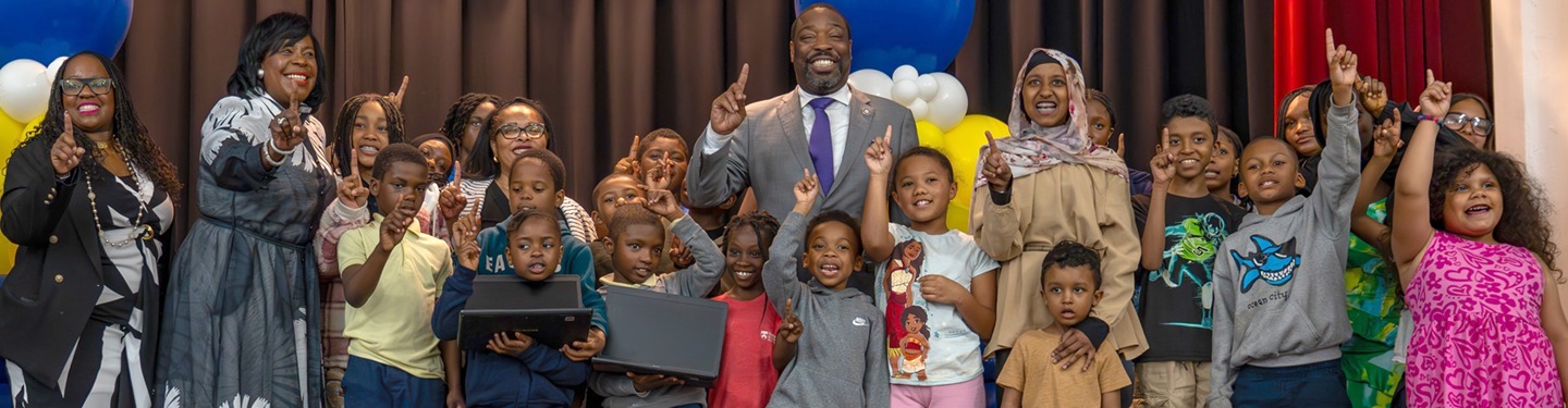 Funcionarios municipales y niños en la distribución de computadoras portátiles