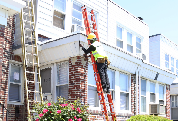 Contractor a ladder fixing a rowhome.