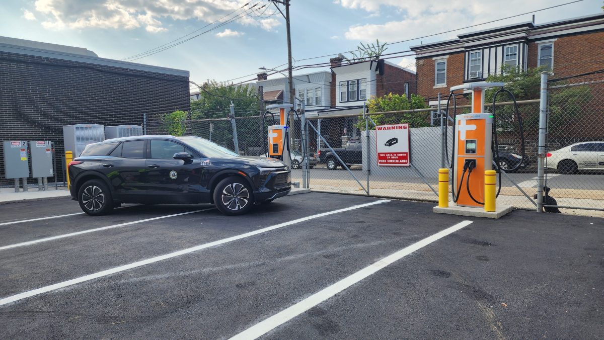 A black municipal electric car drives up to a new electric vehicle charging station at the Fleet Shop 258 facility.