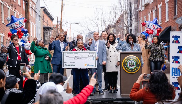 City leadership, including the Mayor, are standing on stage and celebrating the announcement.