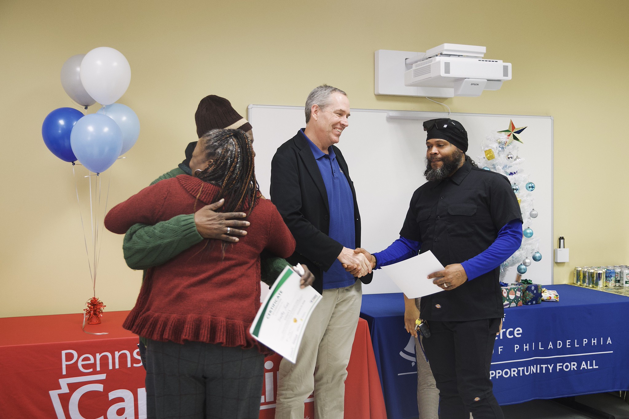 Taking Care of Business Program Cleaning Ambassadors shake hands with Philadelphia Deputy Commerce Director Denis Murphy as they receive their graduation certificates