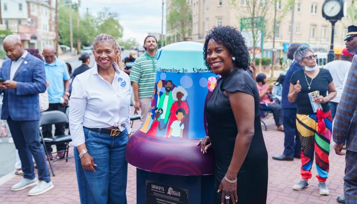 Mayor Parker stands in front of a commemorative liberty bell that was gifted to a local community organization in celebration of America's 250th.