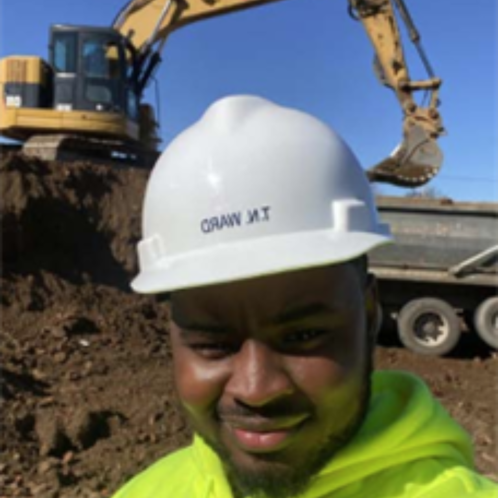construction worker standing in front of excavator
