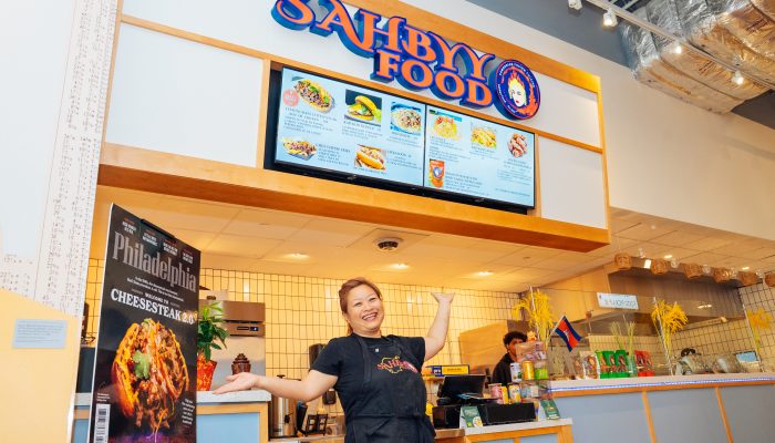 Pidor Yang, owner of Sahbyy Food, stands in front of her business' booth at Gather Food All in University City.