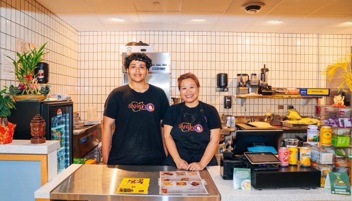 Pidor Yang, owner of Sahbyy Food, and a colleague stand in front of the business' booth at Gather Food All in University City.