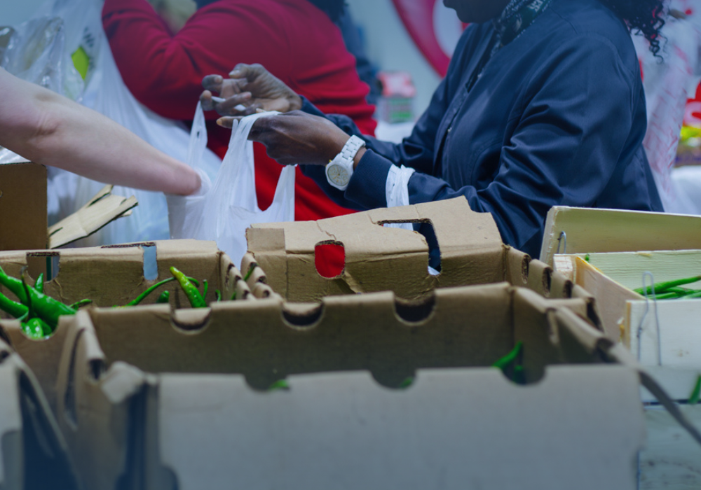 people passing out food into bags at a food drive