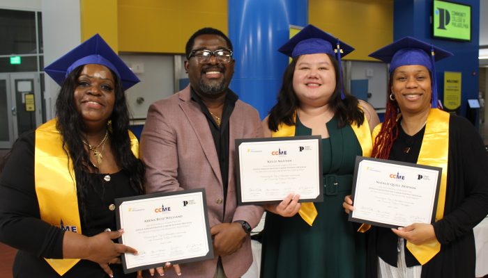Four graduates hold up certificates.