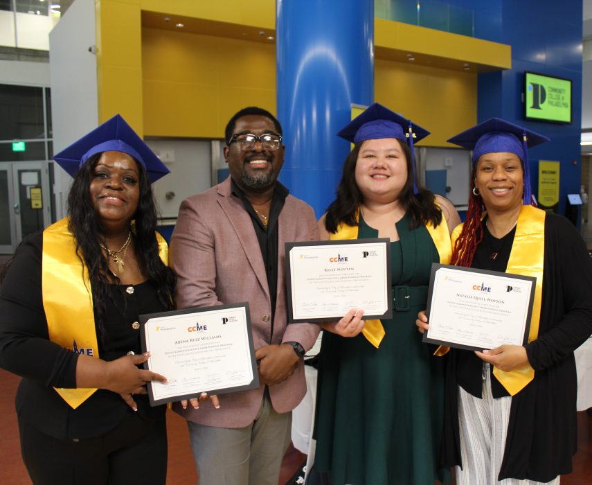 Four graduates hold up certificates.