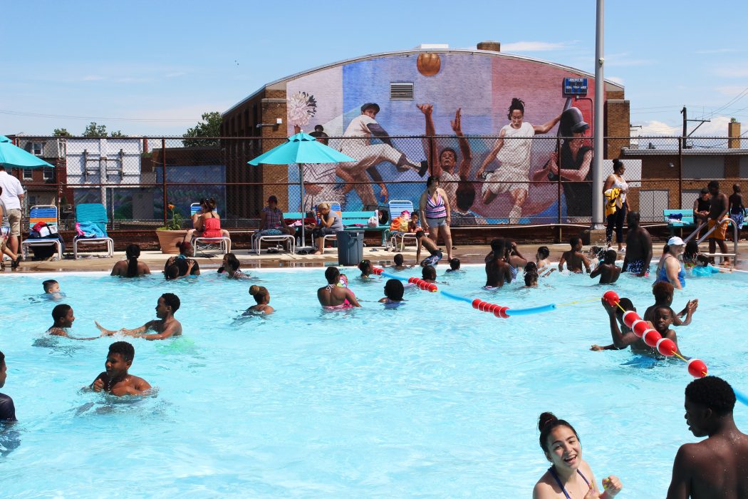 A group of people enjoy a swim in a public pool.