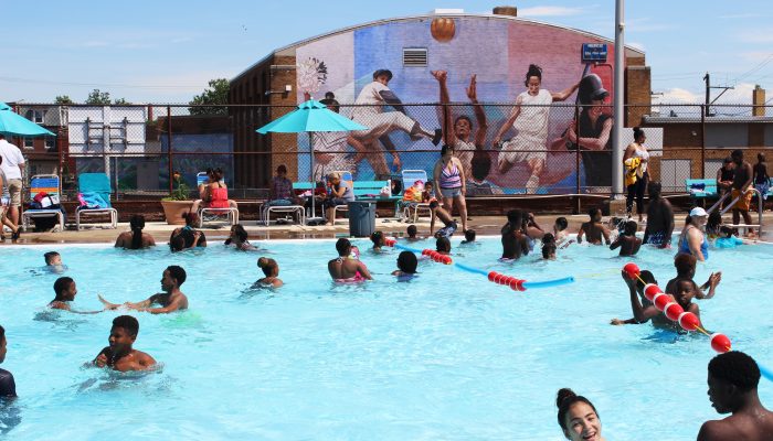 A group of people enjoy a swim in a public pool.