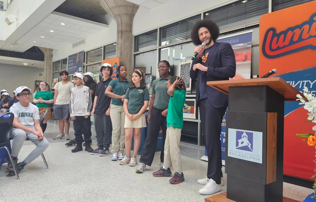A row of students stand with Lumi CEO at the District