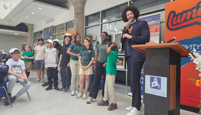 A row of students stand with Lumi CEO at the District