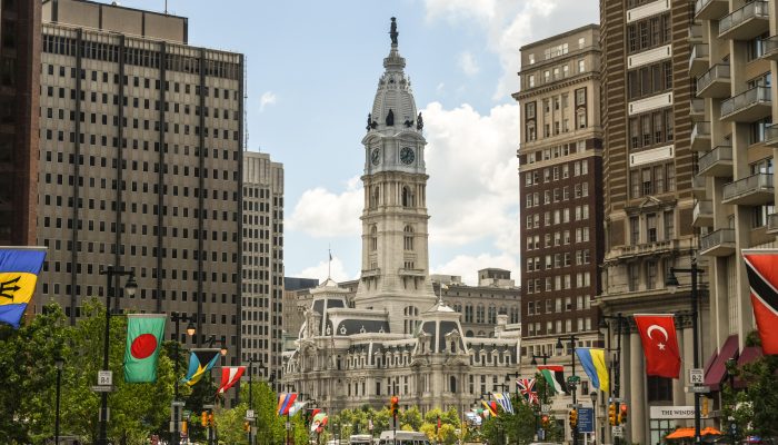 City Hall view from the Benjamin Franklin Parkway with several international flags along the street