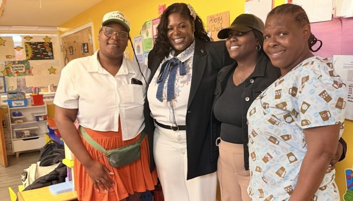 Staff from A Secure Future Academy standing together in a classroom smiling