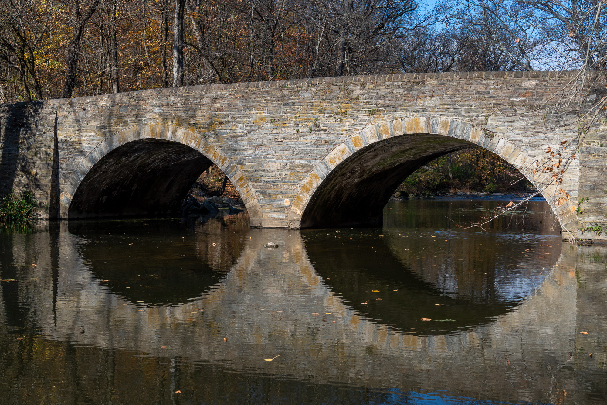 A side view of the bridge’s two stone arches across Wissahickon Creek.