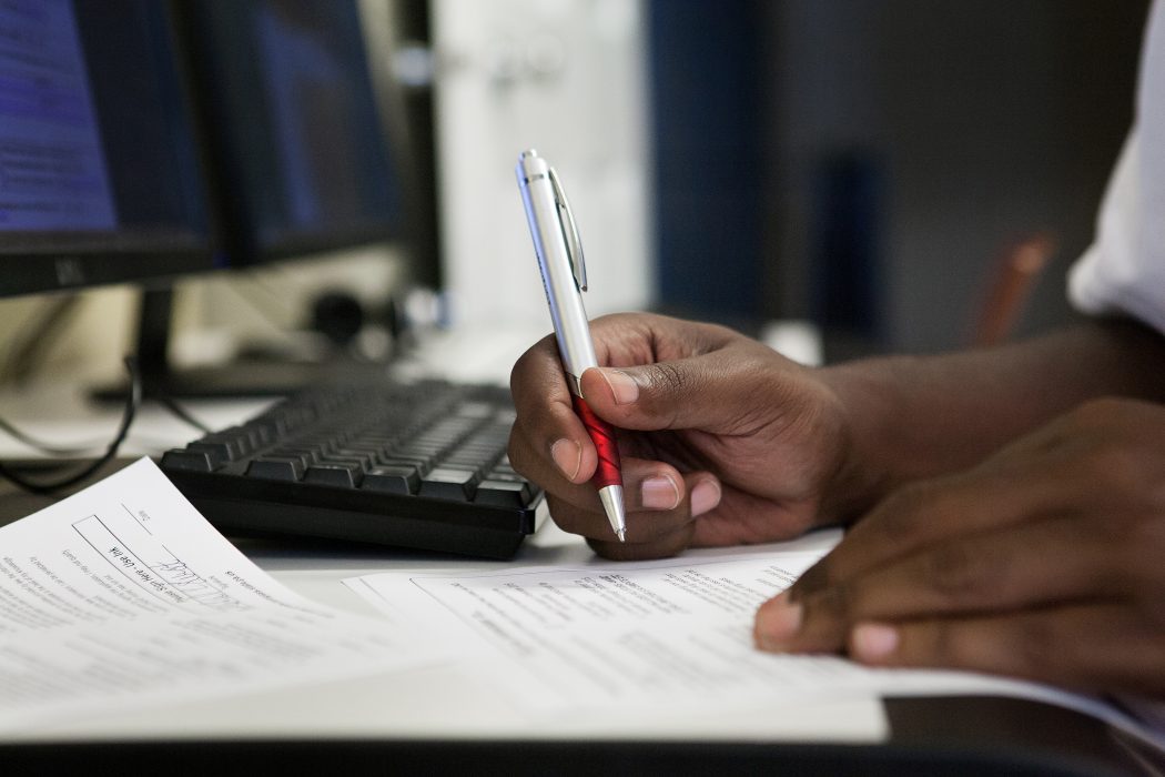 Image of an individual of writing at a desk