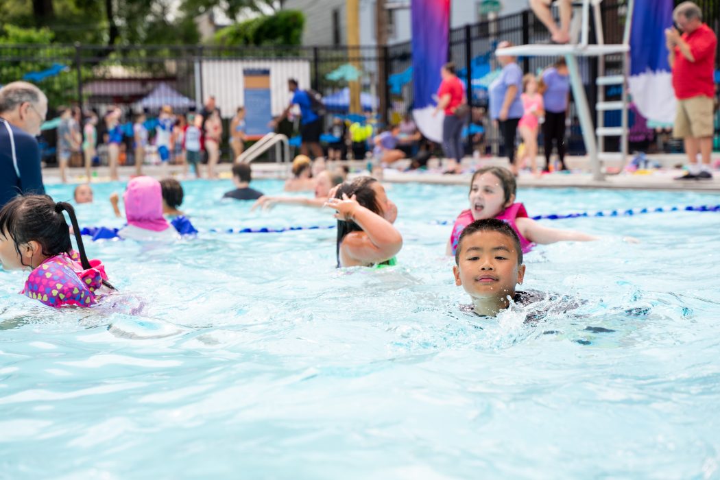Young swimmers enjoy the calm water of a local public pool.