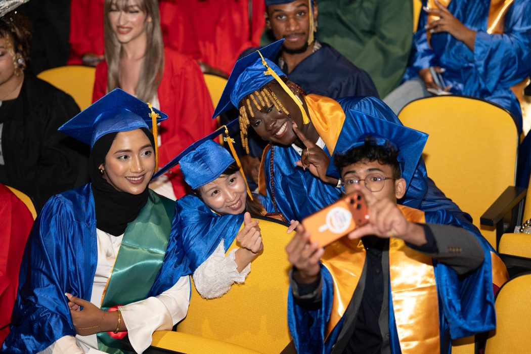Graduates celebrate attaining their high school equivalency diplomas with a selfie.