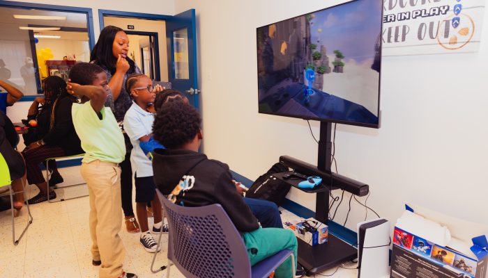 Youth play video games with the program supervisor at the JJC CERC program.