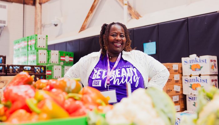 A volunteer stands behind produce in the pop-up grocery market.