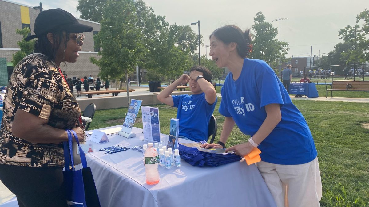 Resident speaks to PHL City ID staff at an outdoor event