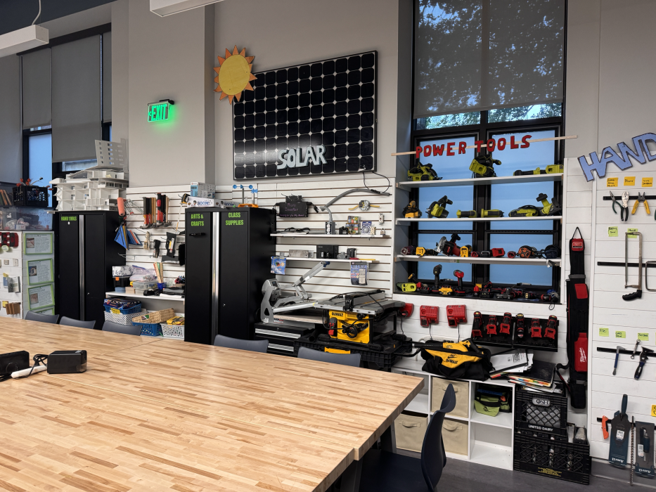 Classroom lined with power tools, work benches, and a solar panel hanging up on the wall.